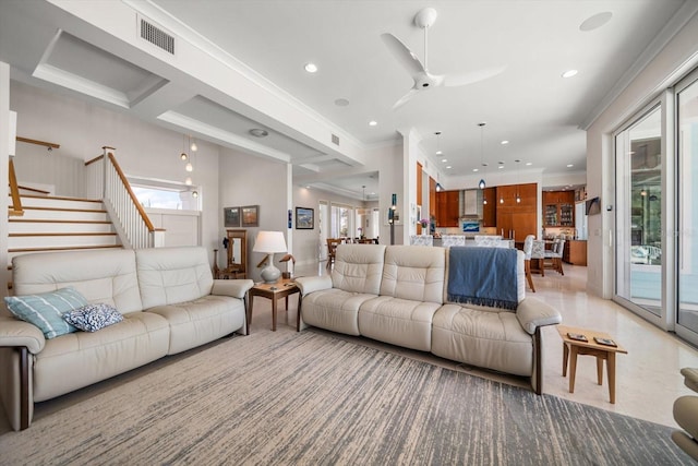 living room with a wealth of natural light, ceiling fan, and ornamental molding