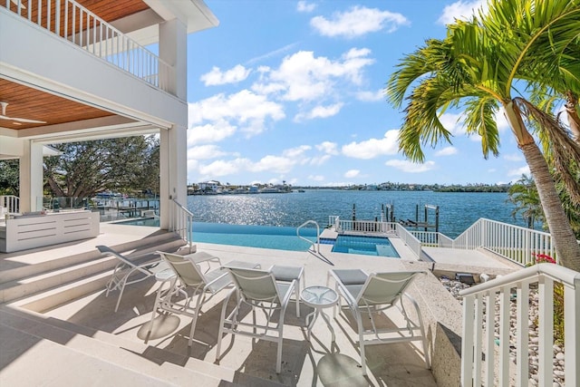 view of pool with a patio area and a water view