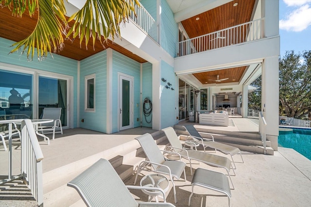 view of patio featuring ceiling fan and a balcony