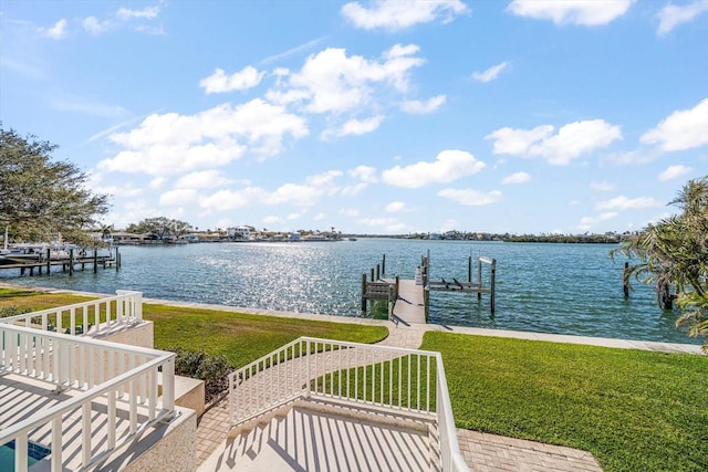 dock area with a lawn and a water view