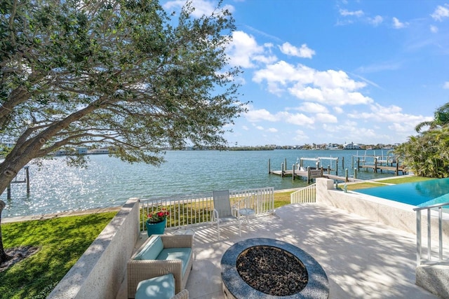 view of patio with a dock, a water view, and an outdoor fire pit