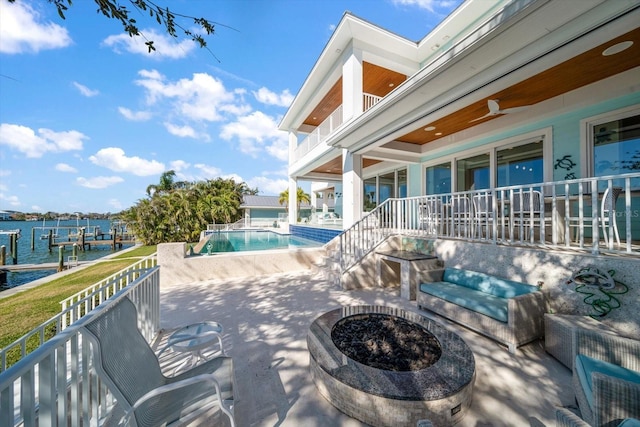 view of swimming pool featuring a water view, an outdoor fire pit, a patio area, and ceiling fan