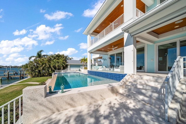 view of swimming pool featuring ceiling fan, a patio area, and a water view