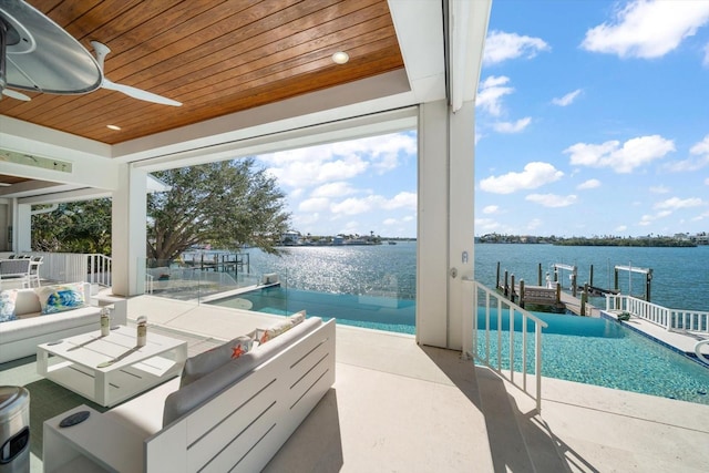 exterior space featuring a patio area, ceiling fan, and a water view