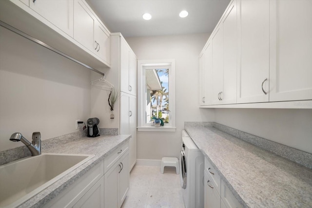 laundry room with cabinets, light tile patterned floors, washer / clothes dryer, and sink