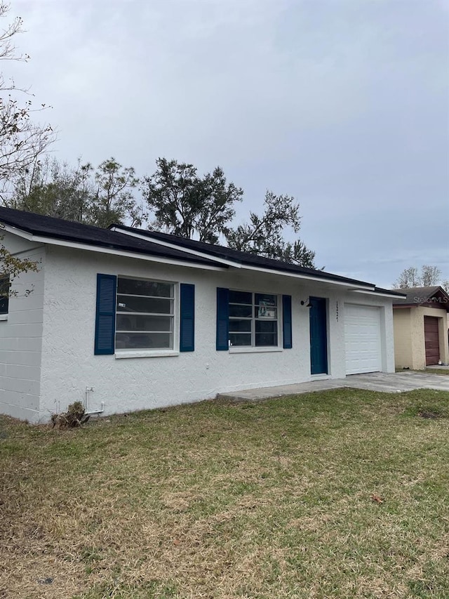 ranch-style home with a front lawn and a garage