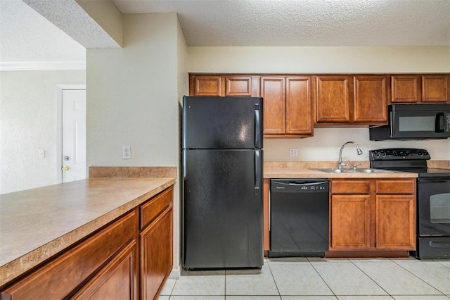 kitchen with sink, light tile patterned floors, black appliances, and a textured ceiling