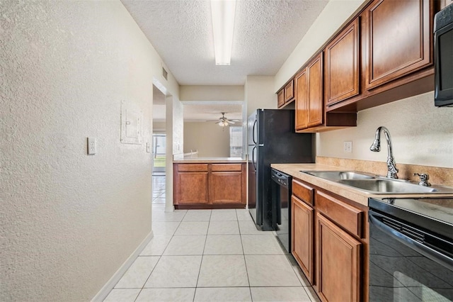 kitchen with black appliances, sink, ceiling fan, light tile patterned floors, and a textured ceiling