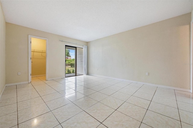 unfurnished room featuring light tile patterned floors and a textured ceiling