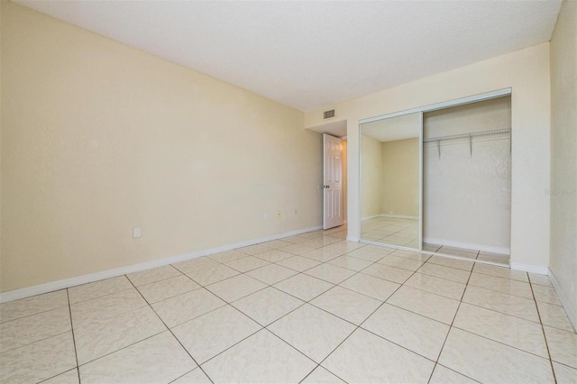 unfurnished bedroom with a closet and light tile patterned flooring