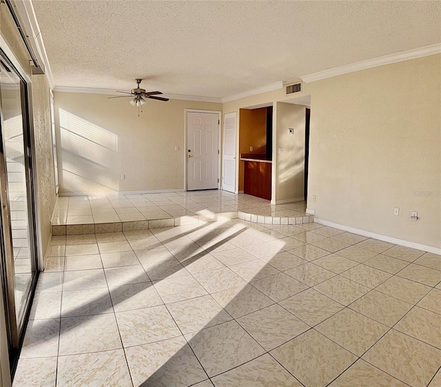 tiled spare room featuring ceiling fan, ornamental molding, and a textured ceiling