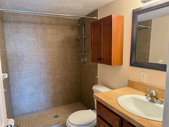 bathroom featuring vanity, a tile shower, a textured ceiling, and toilet