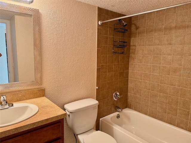 full bathroom featuring tiled shower / bath, vanity, toilet, and a textured ceiling