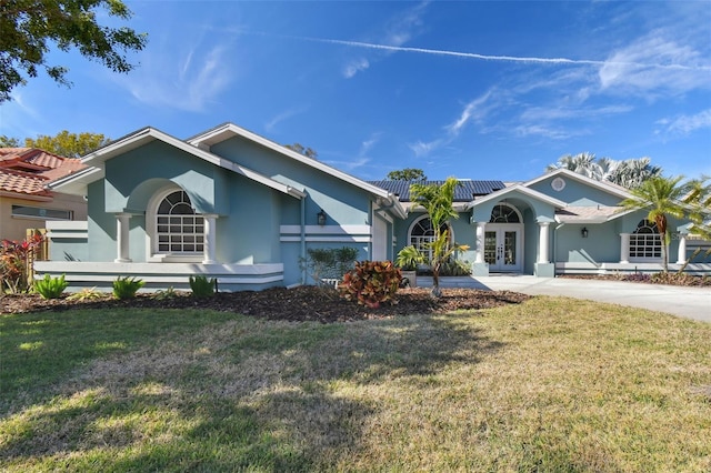 single story home with a front lawn, french doors, and solar panels