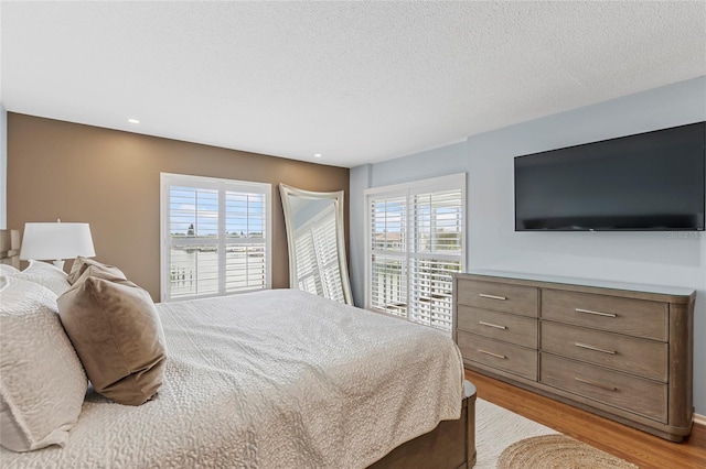 bedroom featuring a textured ceiling and light wood-type flooring