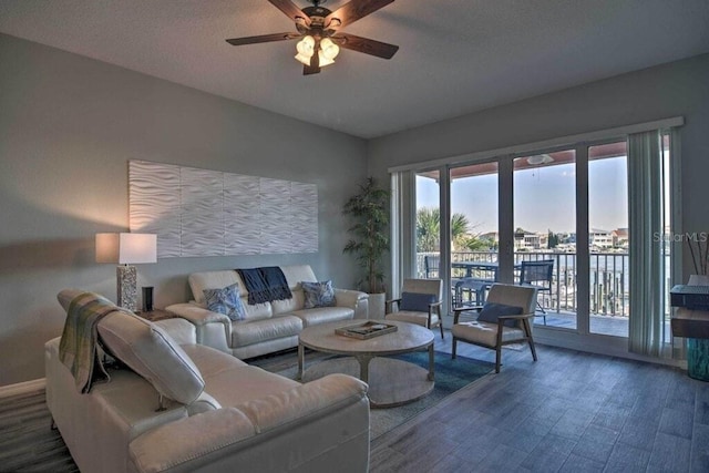 living room featuring ceiling fan, a textured ceiling, dark hardwood / wood-style floors, and a healthy amount of sunlight