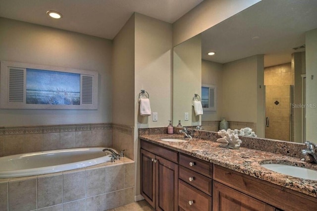 bathroom with plus walk in shower, tile patterned floors, and vanity