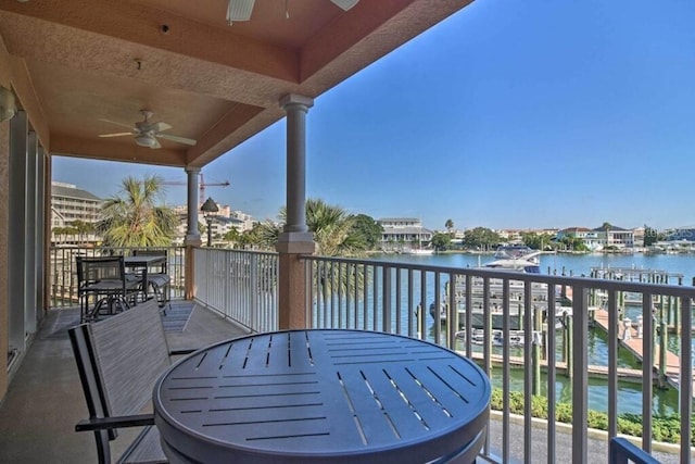 balcony with ceiling fan and a water view