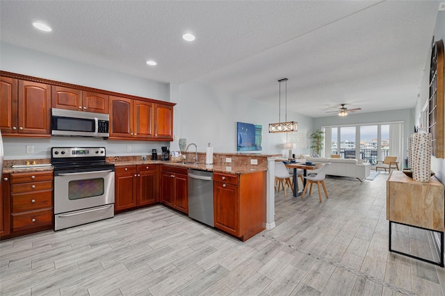 530 S Gulfview Blvd Unit 205, Clearwater, FL 33767 - kitchen with appliances with stainless steel finishes, open floor plan, a peninsula, light wood-style flooring, and recessed lighting