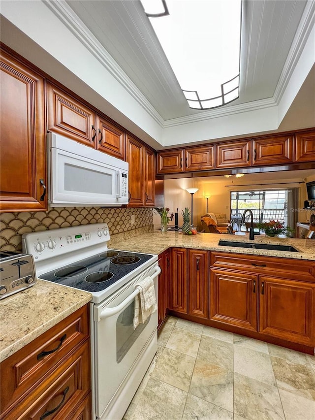 kitchen featuring white appliances, crown molding, decorative backsplash, a tray ceiling, and sink