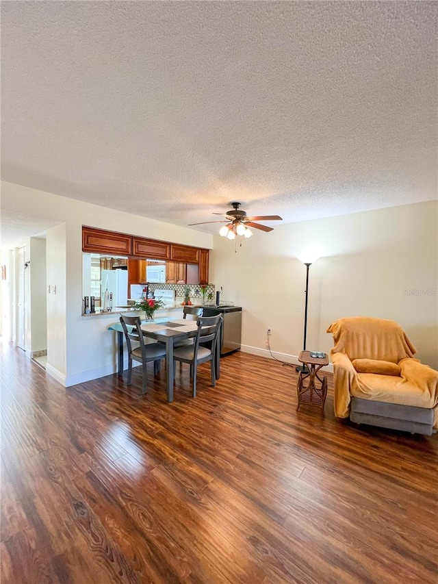 dining area with dark hardwood / wood-style flooring, a textured ceiling, and ceiling fan