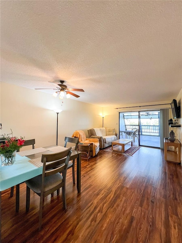 living room featuring ceiling fan, hardwood / wood-style floors, and a textured ceiling