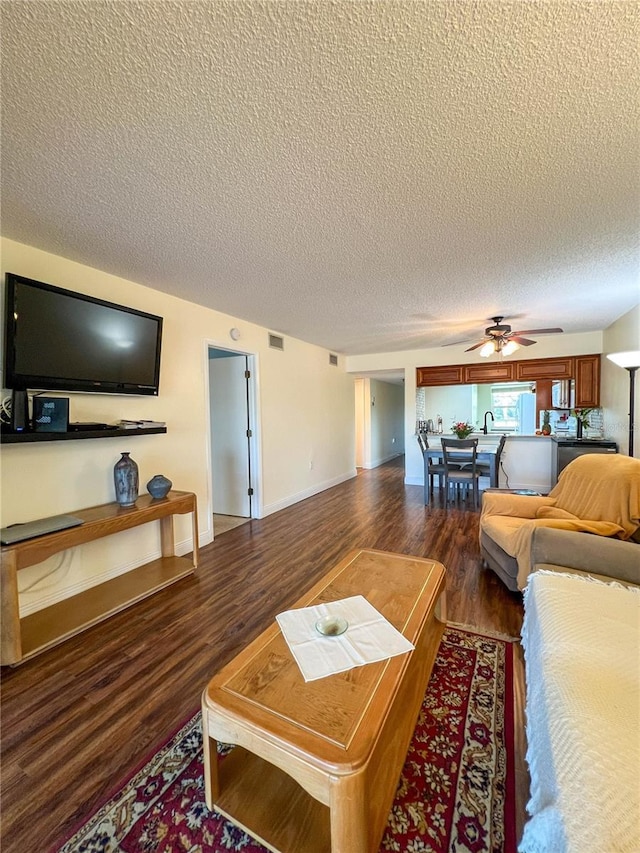 living room featuring a textured ceiling, ceiling fan, and dark hardwood / wood-style floors