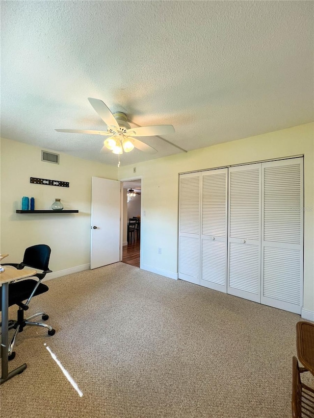 office area with a textured ceiling, ceiling fan, and carpet floors