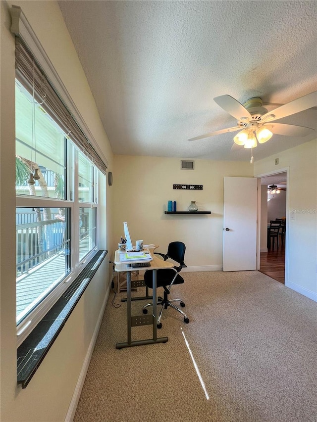 office space featuring carpet flooring, a textured ceiling, and ceiling fan