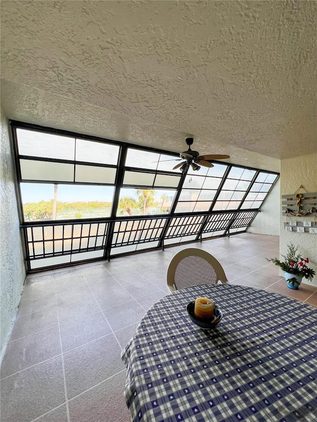 unfurnished sunroom with ceiling fan