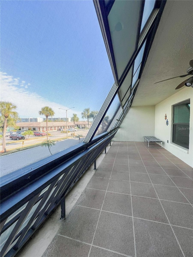 view of patio with ceiling fan and a balcony