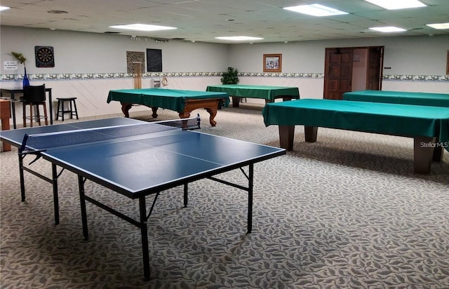 rec room with carpet floors and a paneled ceiling