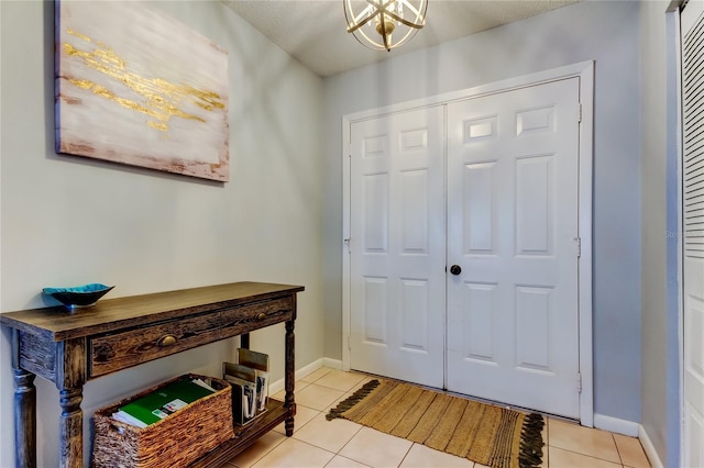 tiled foyer entrance featuring a chandelier