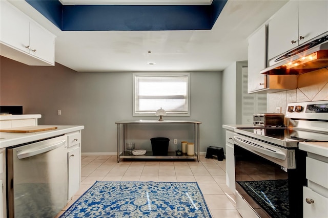 kitchen featuring white cabinets, light tile patterned flooring, backsplash, and appliances with stainless steel finishes