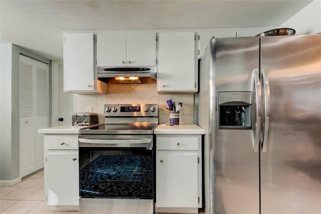 kitchen featuring white cabinets, appliances with stainless steel finishes, light tile patterned flooring, and tasteful backsplash