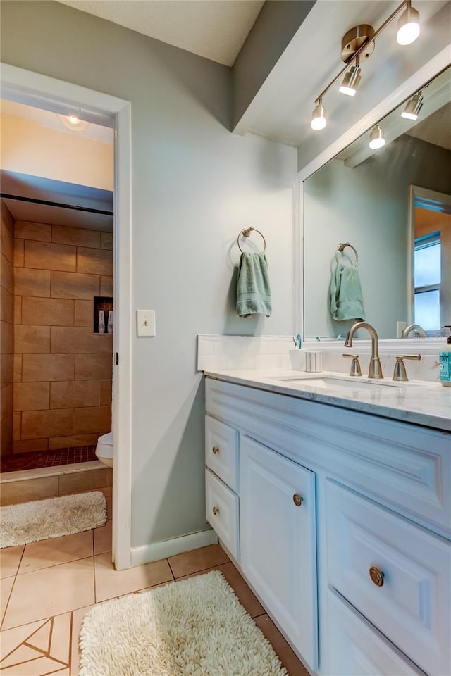 bathroom featuring tile patterned flooring, a shower, vanity, and toilet