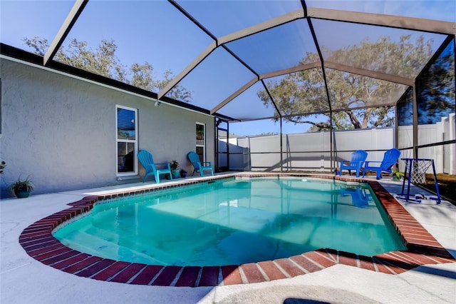 view of swimming pool featuring glass enclosure and a patio