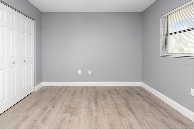 unfurnished bedroom featuring a closet and light hardwood / wood-style flooring