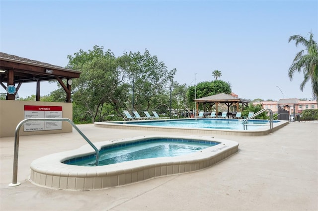 view of pool featuring a gazebo and a hot tub