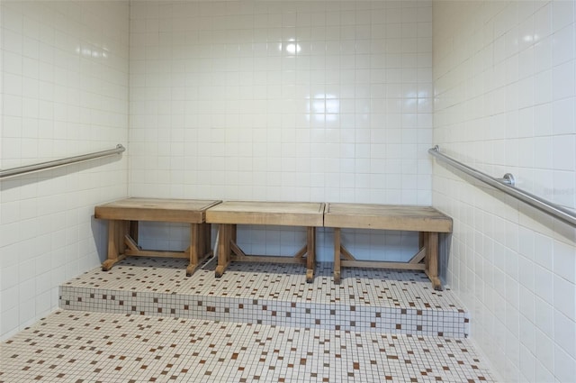 interior space with light tile patterned floors and tile walls