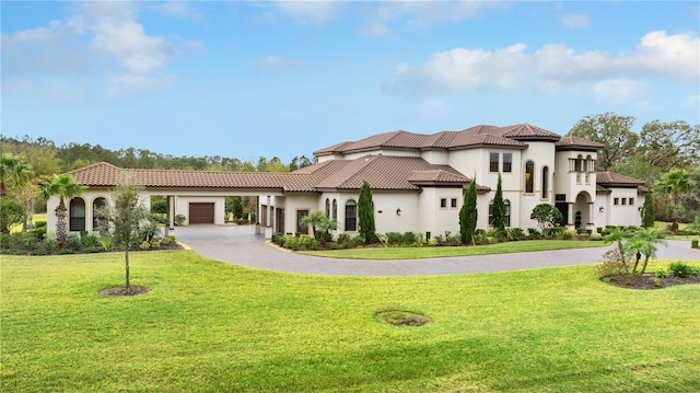 mediterranean / spanish home featuring a garage and a front yard