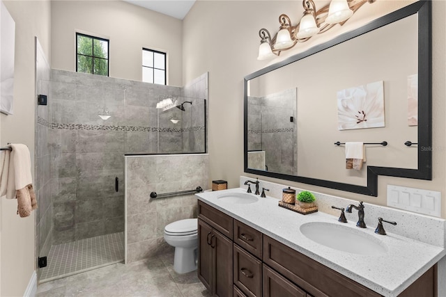 bathroom with an enclosed shower, vanity, and toilet