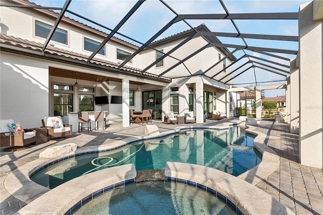 view of swimming pool featuring an in ground hot tub, a patio, ceiling fan, a lanai, and an outdoor living space