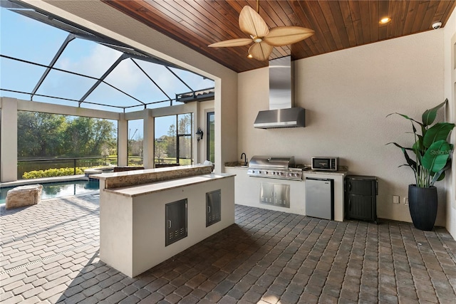 view of patio with a lanai, exterior kitchen, a grill, and ceiling fan