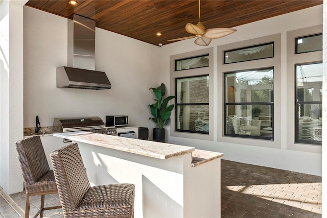 view of patio with ceiling fan, an outdoor kitchen, and an outdoor bar