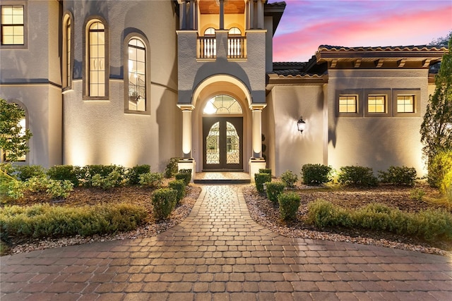 exterior entry at dusk featuring french doors