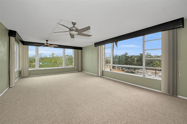 spare room with light carpet, ceiling fan, and a textured ceiling