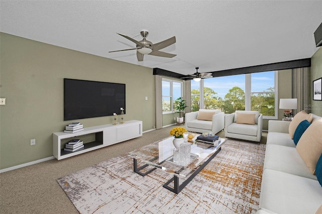 living room featuring carpet, a healthy amount of sunlight, ceiling fan, and a textured ceiling