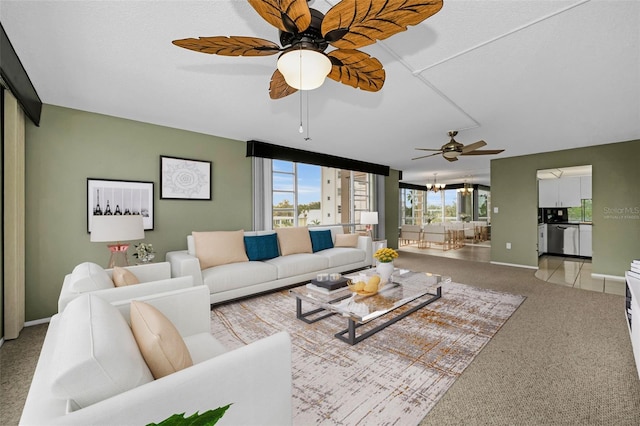 carpeted living room with ceiling fan with notable chandelier