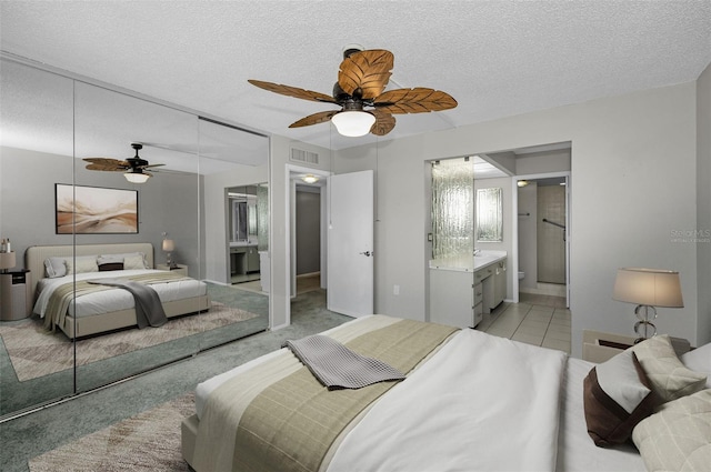 bedroom with ceiling fan, ensuite bathroom, and a closet